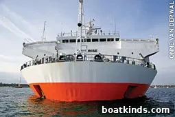 Yachts motor into the flooded bay of a submersible carrier