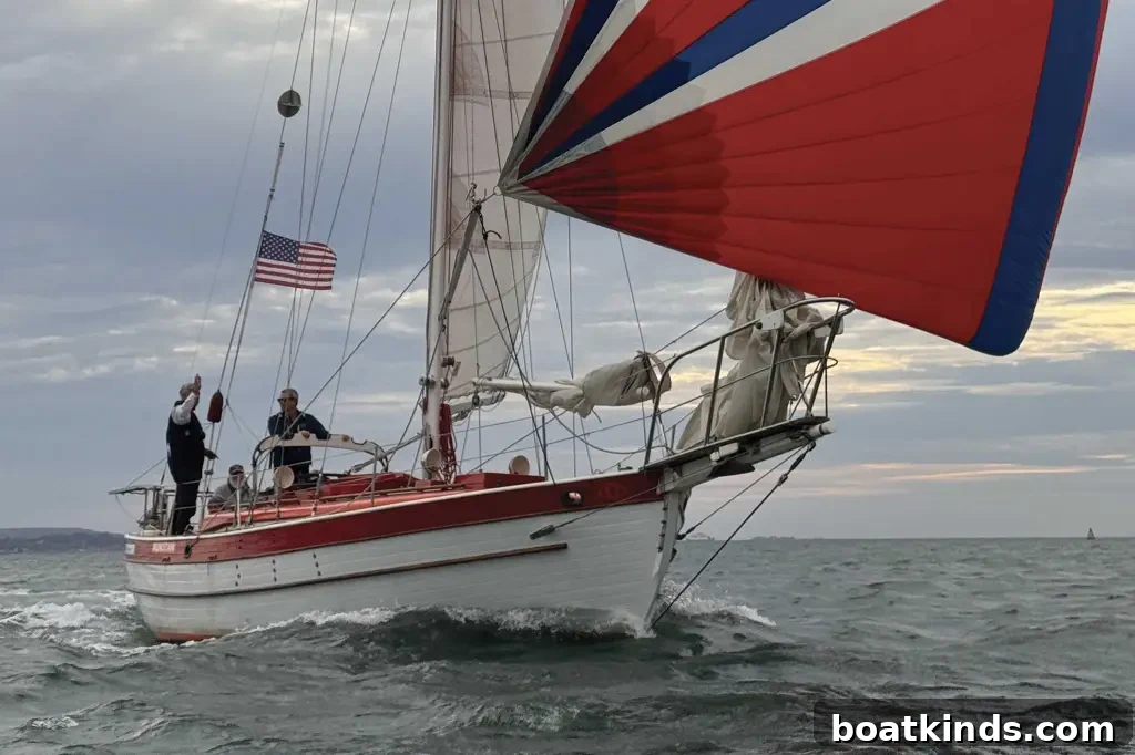 Boat sailing along with a red, white & blue spinnaker